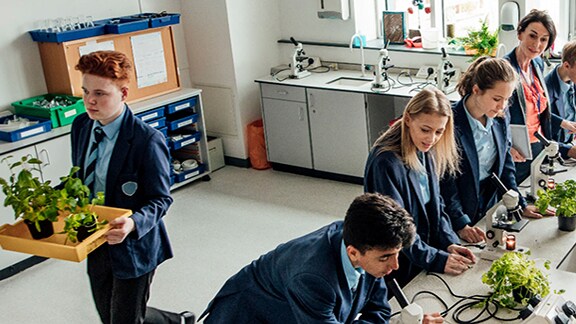 A group of students in the school lab performing some experiments related to plants
