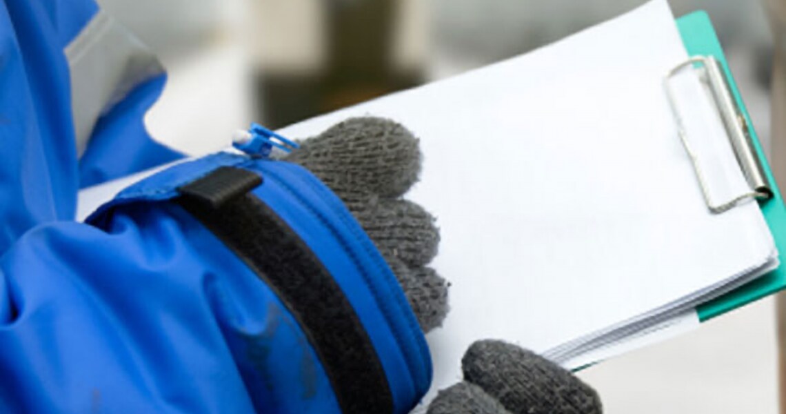 Closeup of a man in uniform writing on a notepad