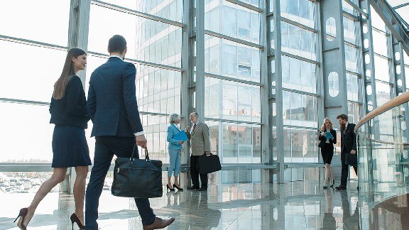 Group of workers talking and walking in an office building