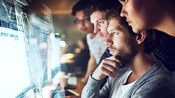 A group of employees checking monitor screen