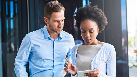 Two employees discussing by looking at tab