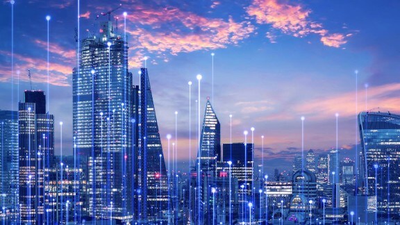 View of the City scrappers in blue against the evening sky overlaid with graphics of transmission nodes